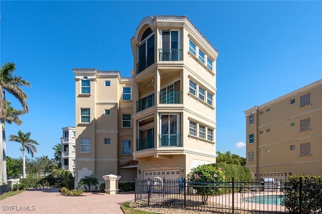 11160 Harbour Yacht Ct Unit B, Fort Myers, FL 33908 - view of property with driveway, an attached garage, fence, and a community pool