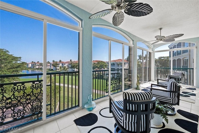 sunroom with a water view and a ceiling fan