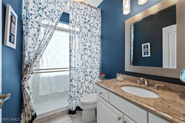 bathroom featuring toilet, tile patterned floors, a shower stall, and vanity