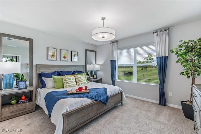 bedroom with light colored carpet, visible vents, and baseboards