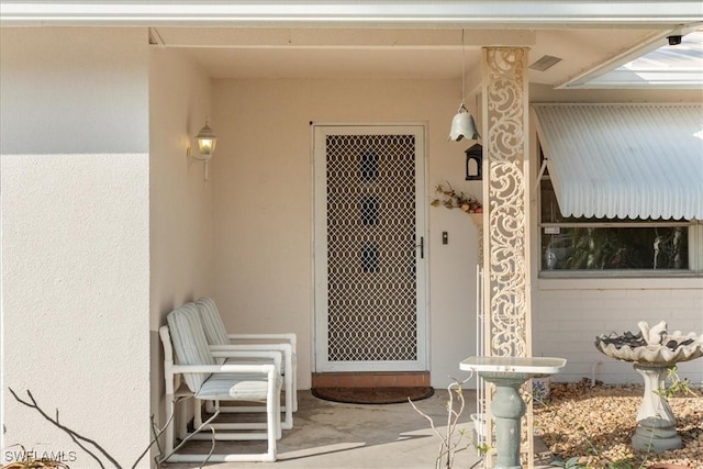 view of exterior entry featuring a patio area