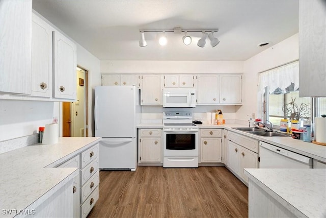 kitchen with white cabinetry, sink, white appliances, and light wood-type flooring