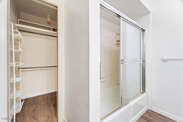 bathroom with hardwood / wood-style flooring and enclosed tub / shower combo