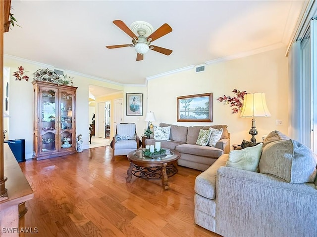 living room featuring crown molding, hardwood / wood-style floors, and ceiling fan