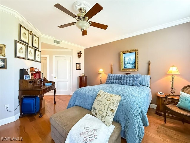 bedroom featuring hardwood / wood-style floors, ornamental molding, and ceiling fan