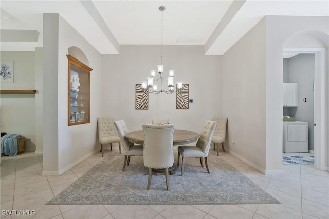 1118 Dorchester Ct, Naples, FL 34104 - dining area with washer / clothes dryer, arched walkways, baseboards, a chandelier, and light tile patterned flooring