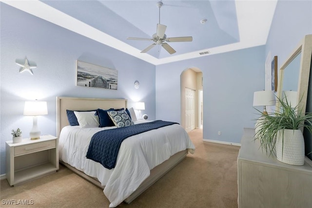 1118 Dorchester Ct, Naples, FL 34104 - bedroom with visible vents, light carpet, baseboards, a tray ceiling, and arched walkways
