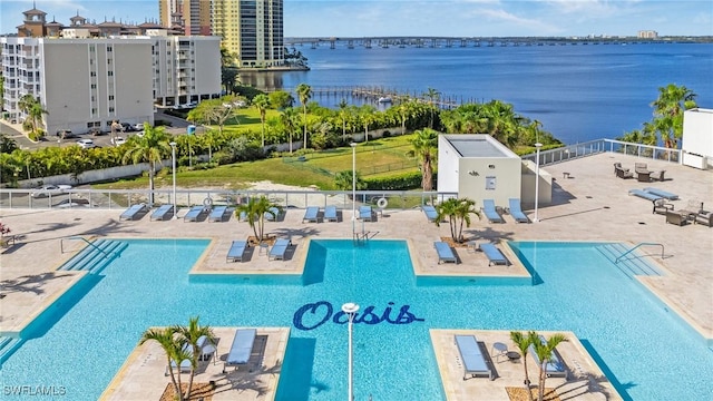 community pool featuring a patio, a water view, and fence