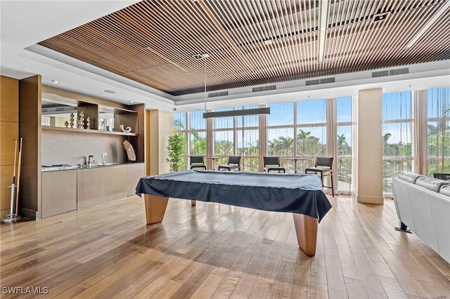 game room featuring wood ceiling, billiards, a raised ceiling, and light wood-style flooring