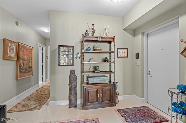 entryway with light tile patterned floors and baseboards