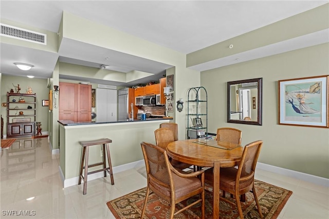 dining room with light tile patterned floors, visible vents, and baseboards