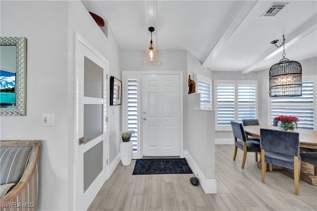 foyer entrance featuring light wood-style floors, visible vents, baseboards, and a notable chandelier