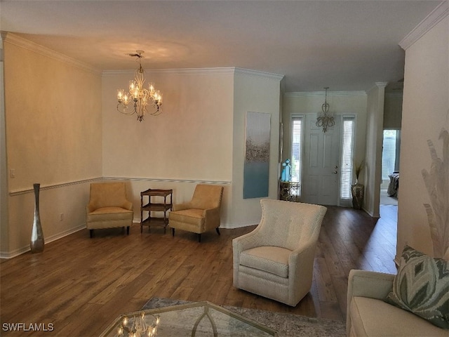 sitting room with ornamental molding, hardwood / wood-style floors, and a chandelier