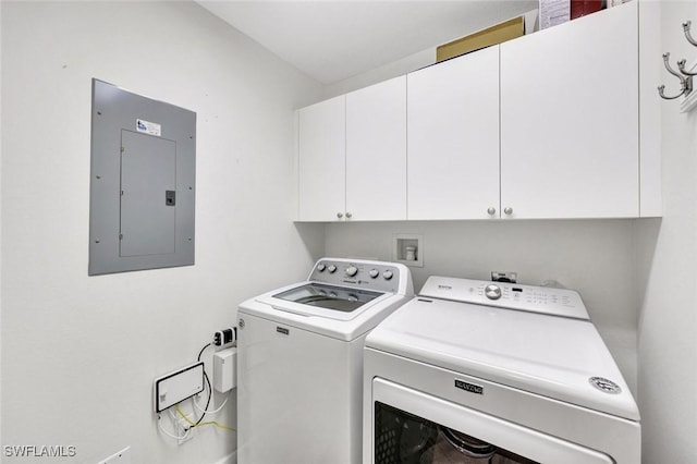 clothes washing area with cabinet space, electric panel, and separate washer and dryer