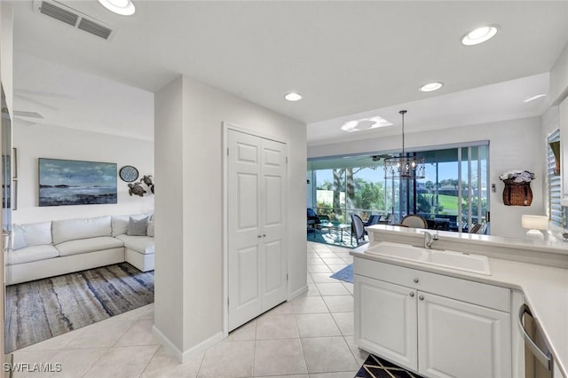 interior space featuring vanity, tile patterned flooring, visible vents, and an inviting chandelier