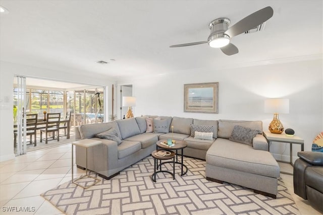 living room featuring crown molding, ceiling fan, and light tile patterned flooring