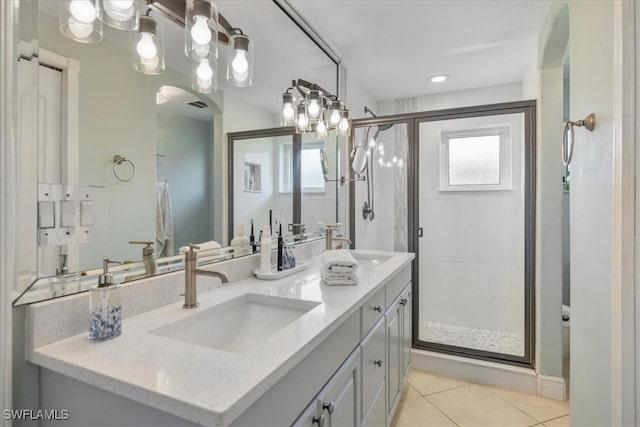 bathroom with tile patterned floors, a shower with door, vanity, and a wealth of natural light