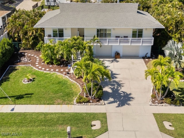 single story home with a garage, driveway, a shingled roof, and a front lawn