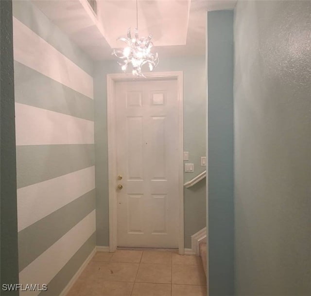 entryway with a notable chandelier and light tile patterned floors