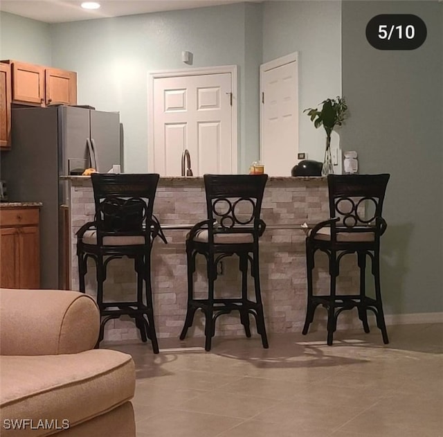 kitchen featuring stainless steel refrigerator and light tile patterned flooring