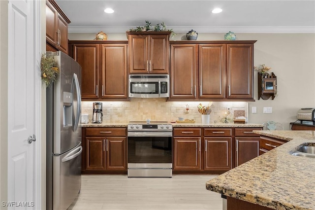 kitchen featuring light hardwood / wood-style flooring, appliances with stainless steel finishes, tasteful backsplash, light stone countertops, and ornamental molding