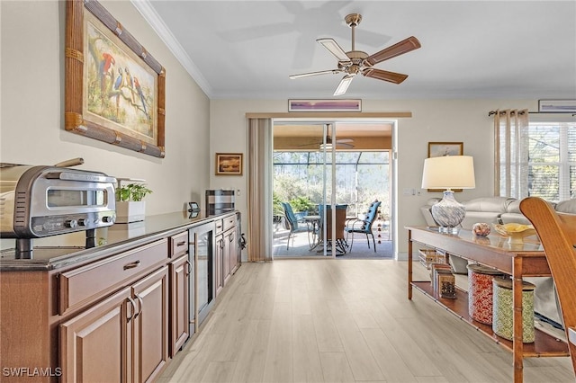 kitchen with ceiling fan, ornamental molding, and light wood-type flooring