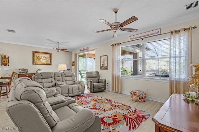 living room featuring ceiling fan, ornamental molding, and light wood-type flooring