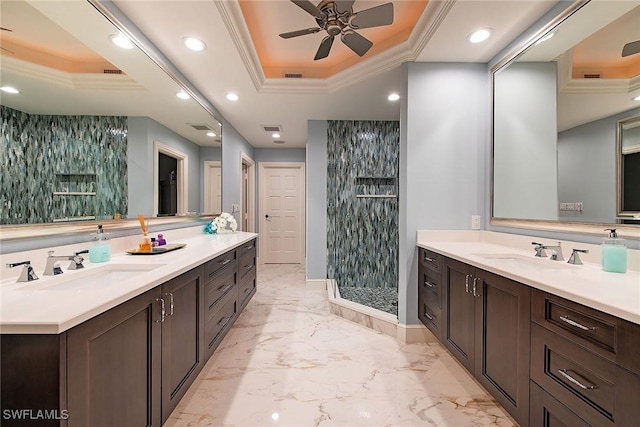 bathroom featuring ornamental molding, tiled shower, vanity, and a tray ceiling