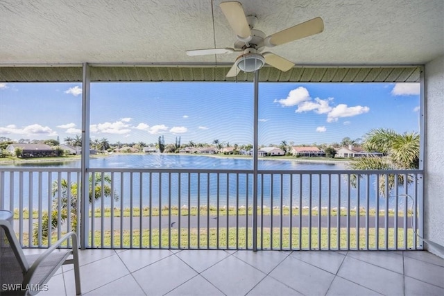 unfurnished sunroom with a water view and ceiling fan