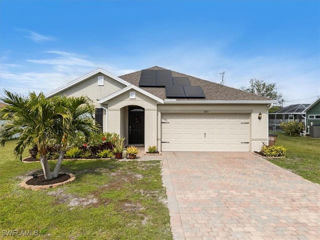 view of front of property featuring a front lawn, solar panels, and a garage