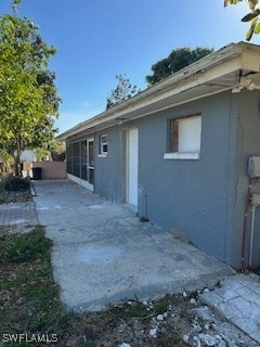 rear view of house featuring stucco siding