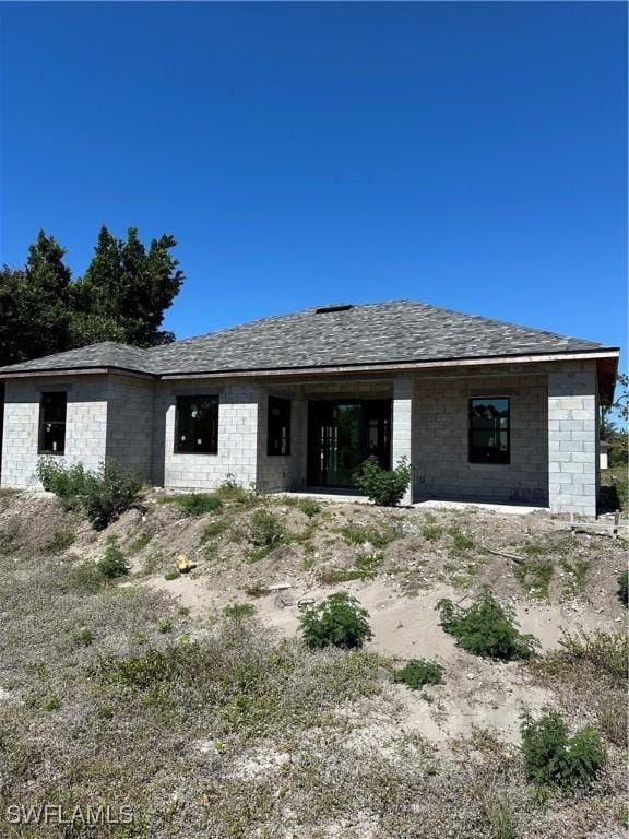 rear view of house with a shingled roof