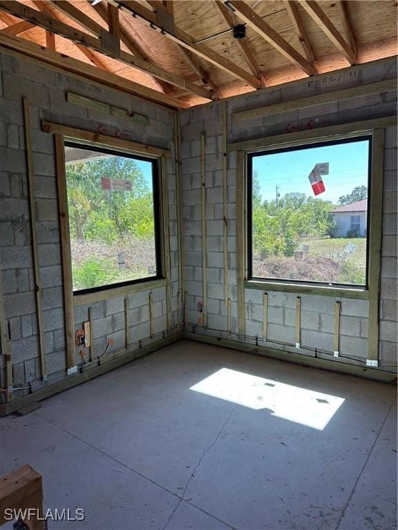 interior space with concrete block wall and unfinished concrete floors