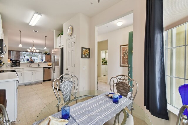 tiled dining room with an inviting chandelier and sink