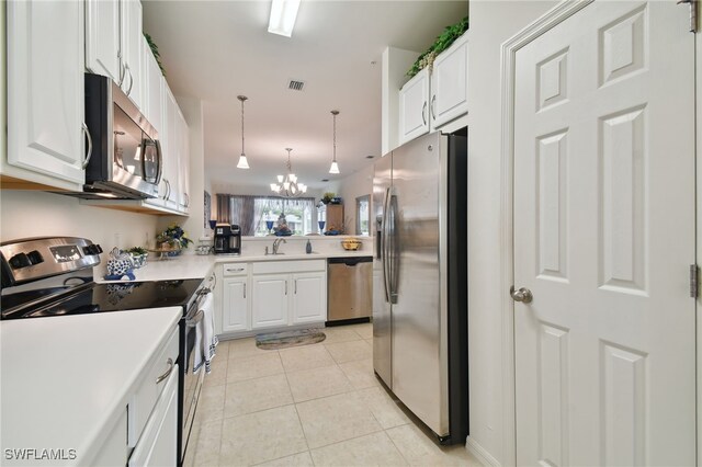 kitchen with appliances with stainless steel finishes, decorative light fixtures, white cabinetry, light tile patterned floors, and kitchen peninsula