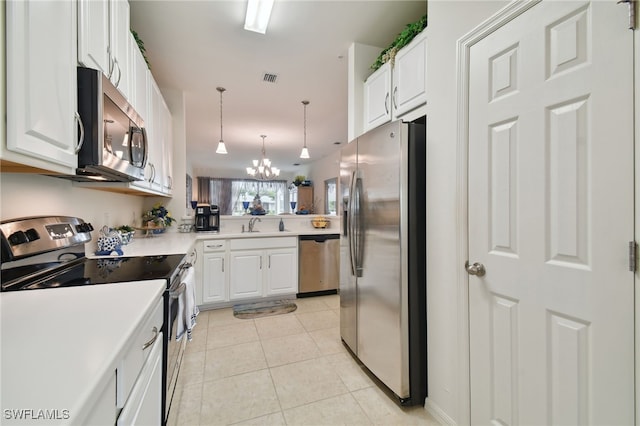 15011 Sandpiper Preserve Blvd Unit 106, Fort Myers, FL 33919 - kitchen featuring appliances with stainless steel finishes, white cabinets, and a chandelier