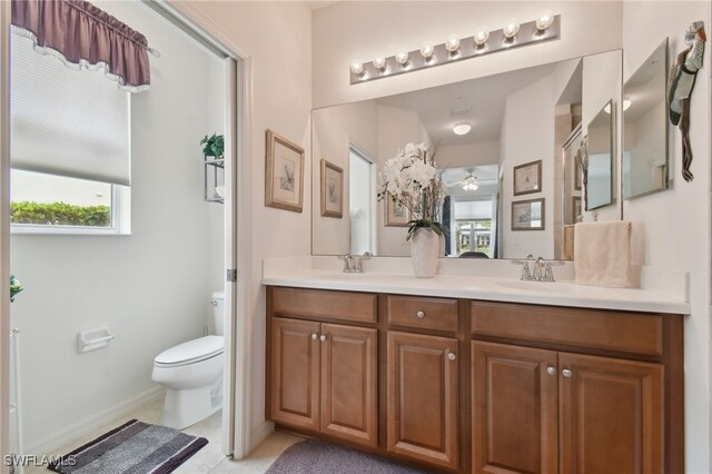 bathroom featuring toilet, an enclosed shower, vanity, ceiling fan, and tile patterned flooring