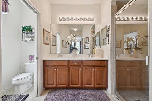 bathroom featuring tile patterned flooring, vanity, an enclosed shower, and toilet