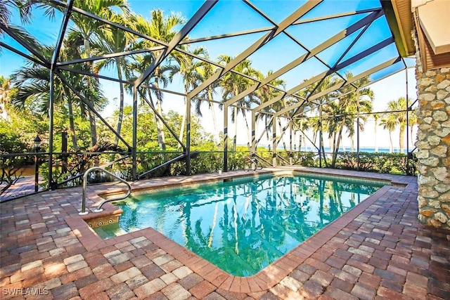 view of swimming pool featuring glass enclosure and a patio area