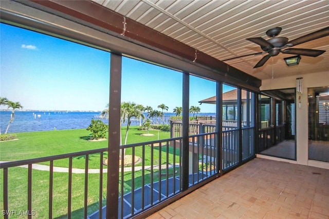 unfurnished sunroom featuring a water view and ceiling fan