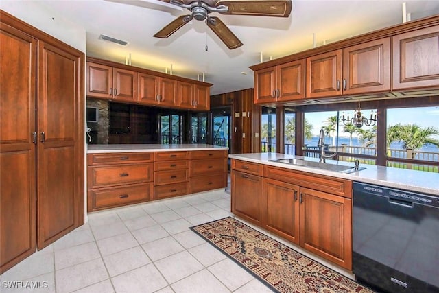 kitchen featuring a water view, ceiling fan with notable chandelier, light tile patterned floors, sink, and black dishwasher