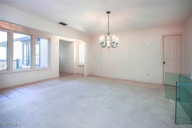 carpeted spare room with a chandelier