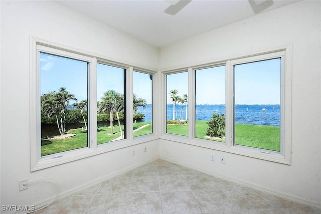 unfurnished room featuring a water view and ceiling fan