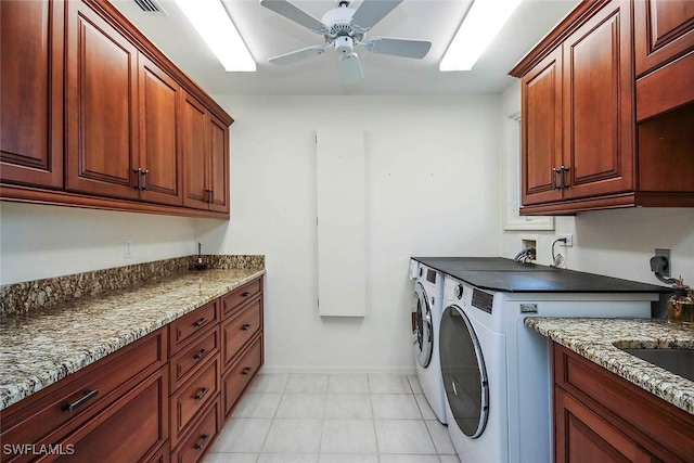 clothes washing area featuring washer and dryer, cabinets, and ceiling fan