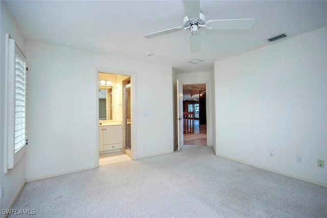 unfurnished bedroom featuring light colored carpet, ceiling fan, and ensuite bath