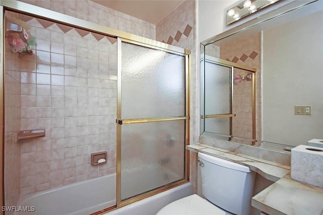 bathroom with toilet and shower / bath combination with glass door