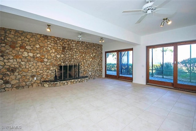 unfurnished living room featuring a large fireplace and ceiling fan