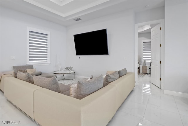 living room featuring marble finish floor, baseboards, visible vents, and a raised ceiling