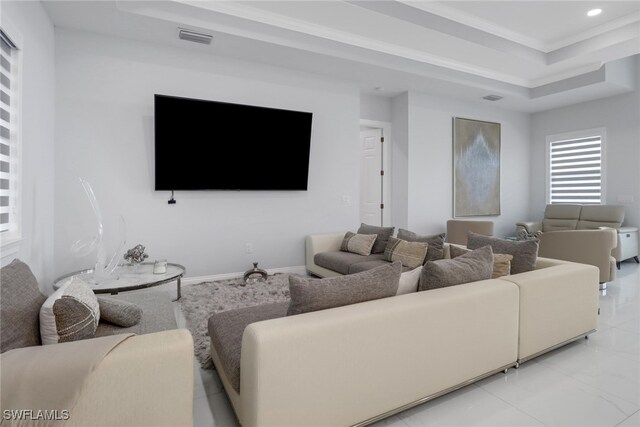 living area with a tray ceiling, visible vents, baseboards, and recessed lighting