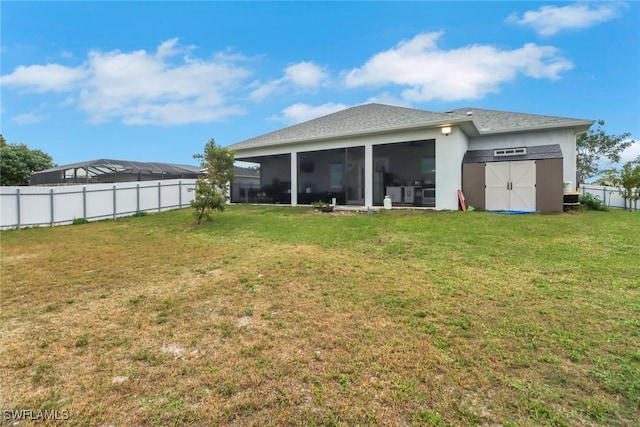 rear view of property with a lawn, a storage shed, a sunroom, fence, and an outdoor structure